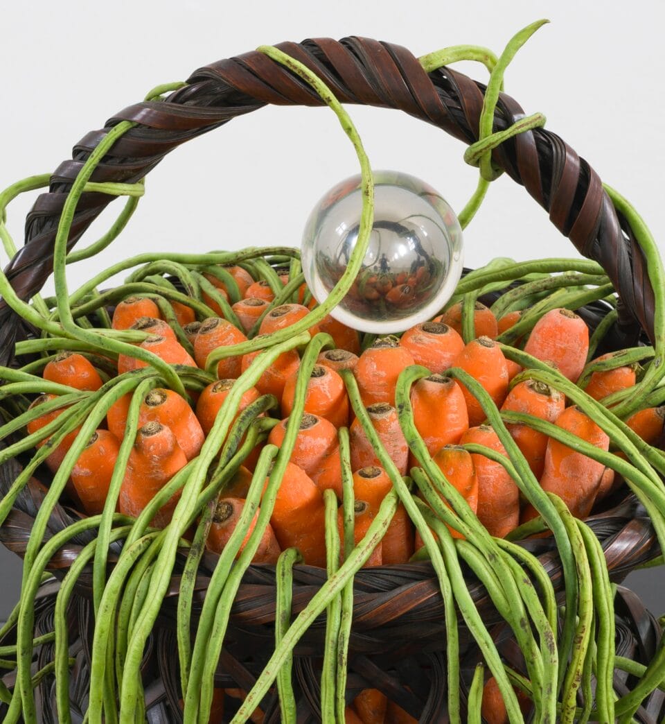 carrots with green stems peeking out from a basket